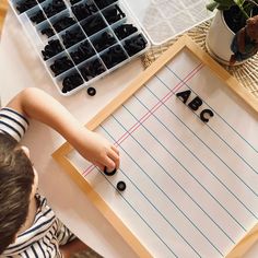 a young boy is playing with letters on a piece of paper that says abcc