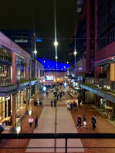 people are walking down the street at night