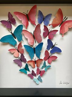 colorful butterflies are arranged in a shadow box