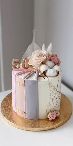 a cake decorated with books and flowers on a plate