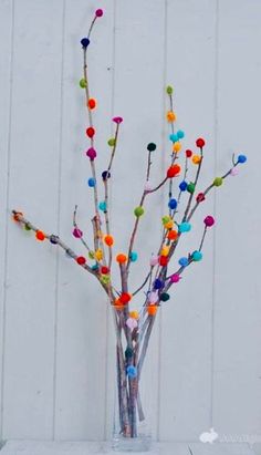 a vase filled with colorful pom - poms sitting on top of a table