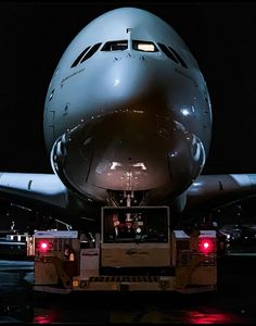 an airplane is parked on the tarmac at night with its lights on and it's door open