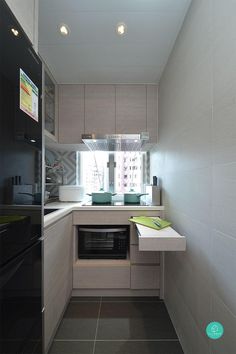 a small kitchen with an oven, microwave and sink in the center of the room