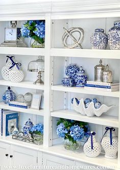 blue and white vases are displayed on shelves in a room with bookshelves