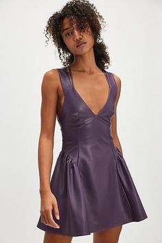 So bold, this vegan leather mini features a flattering fit-and-flare silhouette and deep V-neckline with an open-back and gathered detail at the hips. **Fit:** Fit-and-flare style, A-line hem **Features:** Soft vegan leather fabrication, deep V-neckline, defined seams throughout, gathered hip detail for added dimension, open-back with strappy detailing, self-tying closure, zipper at back **Why We ❤ It:** Perfect with a pair of boots or your favorite flats, this mini is a versatile addition to any wardrobe. | Vera Mini Dress by Free People in Purple, Size: M Dark Purple Mini Dress, Purple Mini Dress, Free People Dress, Leather Mini, Dark Purple, Boho Outfits, Fit And Flare, Vegan Leather, The Dress