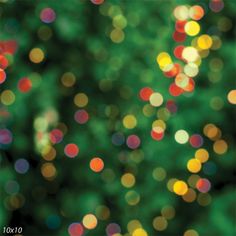 the blurry image shows many different colored lights in green and yellow colors, as well as trees