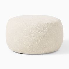 a white round ottoman sitting on top of a floor