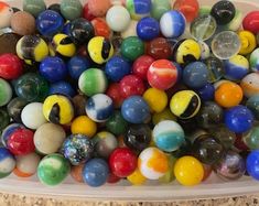 a plastic container filled with lots of different colored marbles