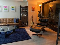 a living room filled with furniture and a glass top coffee table in front of a window