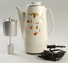 a white tea pot with an electric cord plugged into it and another item next to it