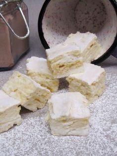 several pieces of cake sitting on top of a counter next to a cup and saucer