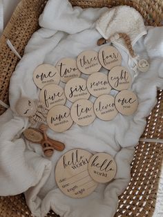 a basket filled with lots of wooden tags on top of a white cloth covered table