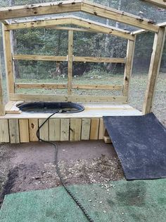 a hot tub built into the side of a wooden structure with a black mat under it