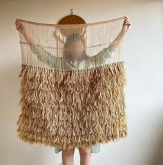 a woman holding up a large piece of straw