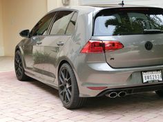 the back end of a silver volkswagen golf gtr parked in front of a house