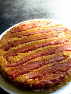 a bacon cake sitting on top of a white plate