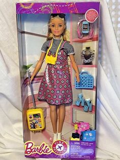 the barbie doll is wearing a dress and holding a suitcase