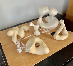 some white sculptures sitting on top of a wooden table