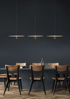 a dining room table with chairs and lights hanging from the ceiling