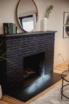 a living room with a fire place and a round mirror on top of the fireplace