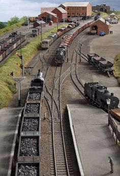 there are many trains that are on the tracks next to each other in this miniature town