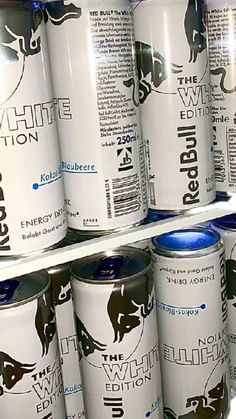 several cans of red bull energy drink stacked on top of each other in a refrigerator