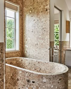 a bath tub sitting next to a window in a bathroom