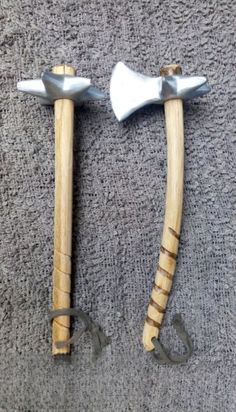 two wooden and metal hammers laying next to each other on a carpeted floor