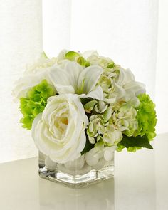 a vase filled with white and green flowers