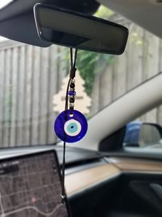 the inside of a car with an evil eye hanging from it's dash board