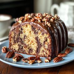 a piece of cake with chocolate frosting and pecans around it on a blue plate