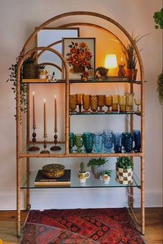 a shelf filled with vases and candles on top of a rug