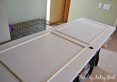 an unfinished kitchen counter top in the process of being painted with white paint and cabinet doors