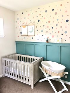 a baby's room with polka dot wallpaper and a crib in the corner