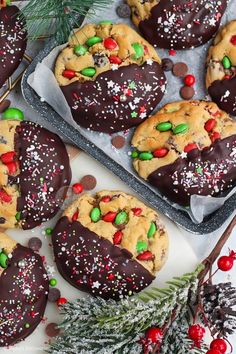 chocolate chip cookies with candy and sprinkles on tray next to pine cones