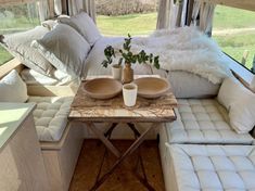 a living area with couches, tables and pillows on the inside of a camper