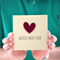 a man holding up a card with a heart on it that says, best daddy ever