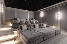 an empty movie room with couches and lamps on the walls, stars in the ceiling