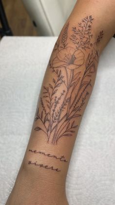 a woman's arm with flowers and words tattooed on the side of her arm