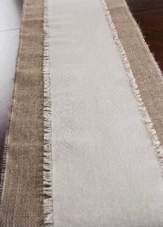 a white and brown striped rug sitting on top of a wooden floor