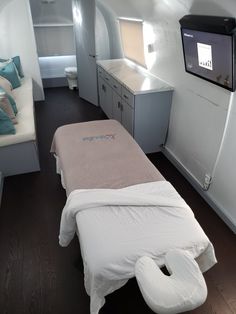 an airplane cabin with a bed and television