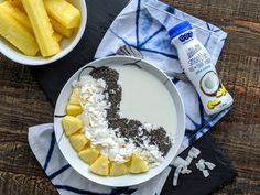 a bowl of oatmeal with bananas and chia seeds next to a bottle of milk