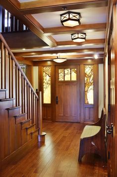 an entryway with wood paneling and wooden stairs leading up to the second floor