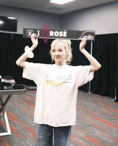 a girl holding up a sign that says rose