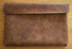 a brown leather case sitting on top of a wooden table