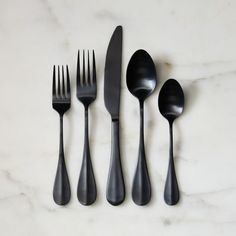 four forks, two spoons and one knife on a marble surface