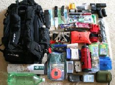 the contents of a backpack are laid out on the floor next to some water bottles