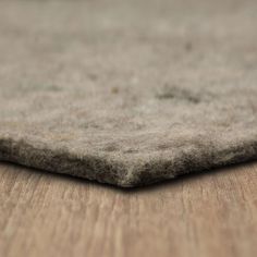 a close up view of the top of a rug on a wooden floor with no one around it