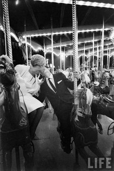 a man kissing a woman on a merry go round