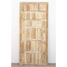 an old wooden door sitting on top of a tile floor next to a white wall